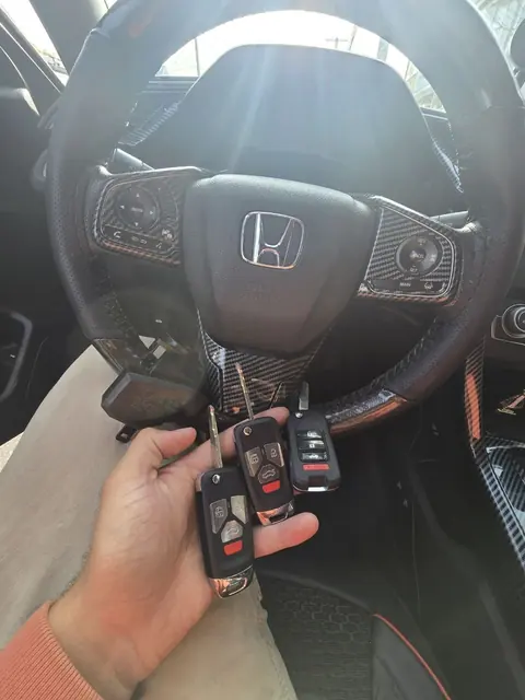 Three new Honda flip keys in front of the steering wheel